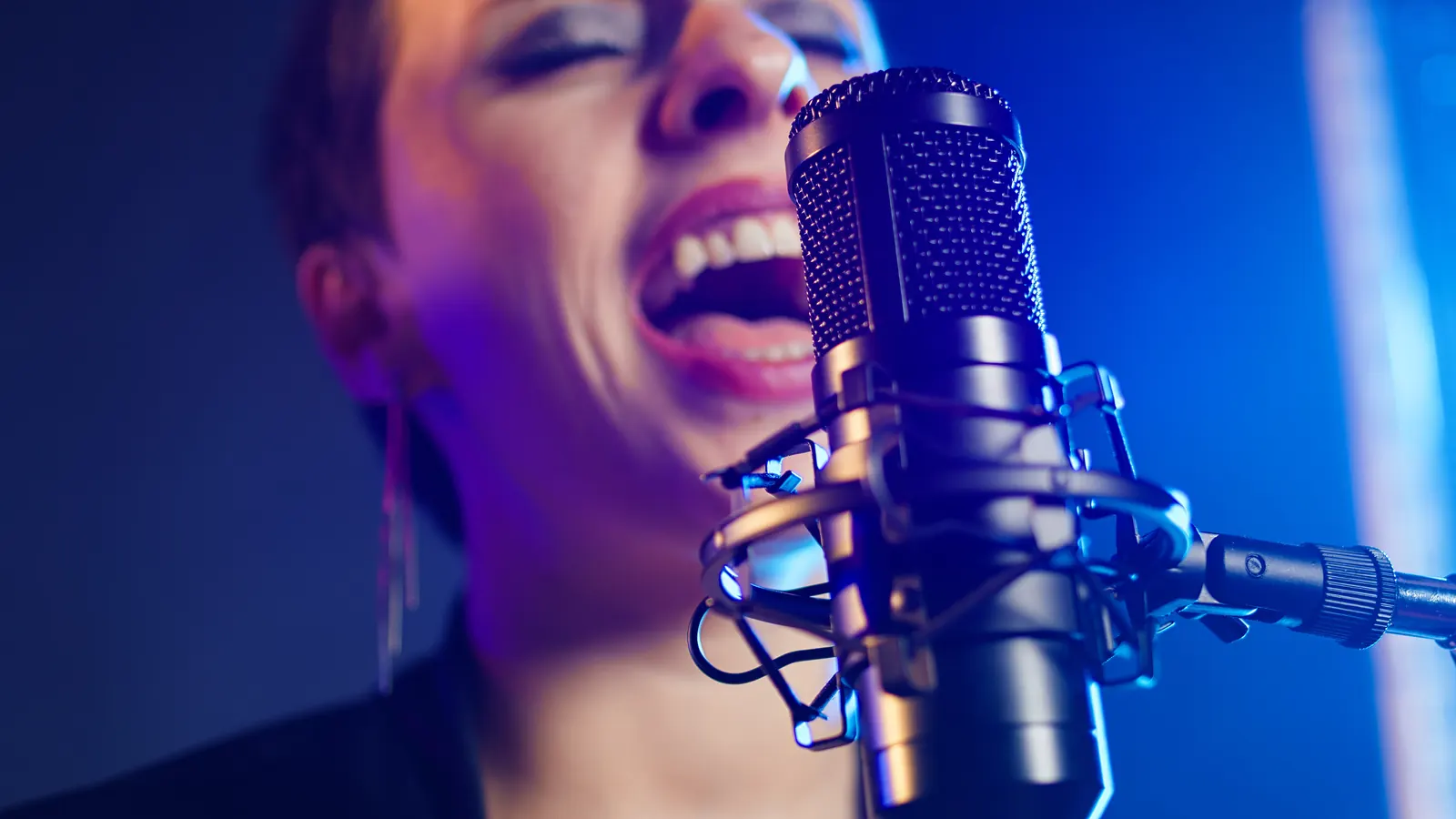 Sängerin singt mit voller Energie in ein Mikrofon